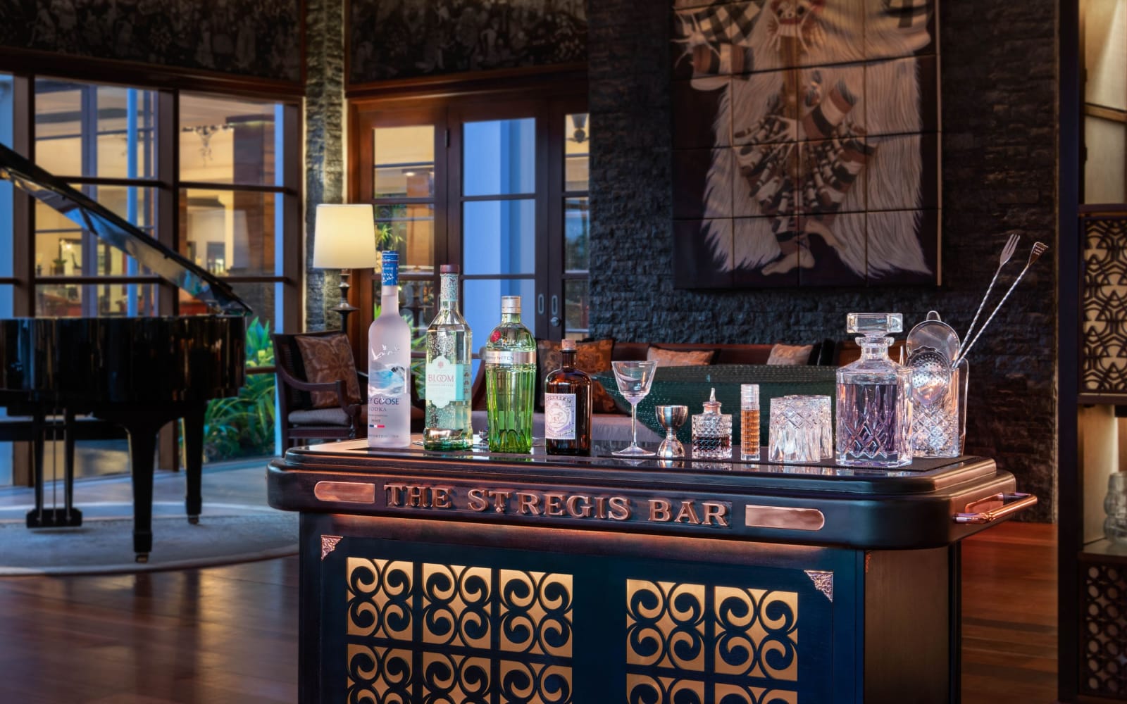 深色木質吧檯上寫著 The St. Regis Bar，後方是一架平台鋼琴