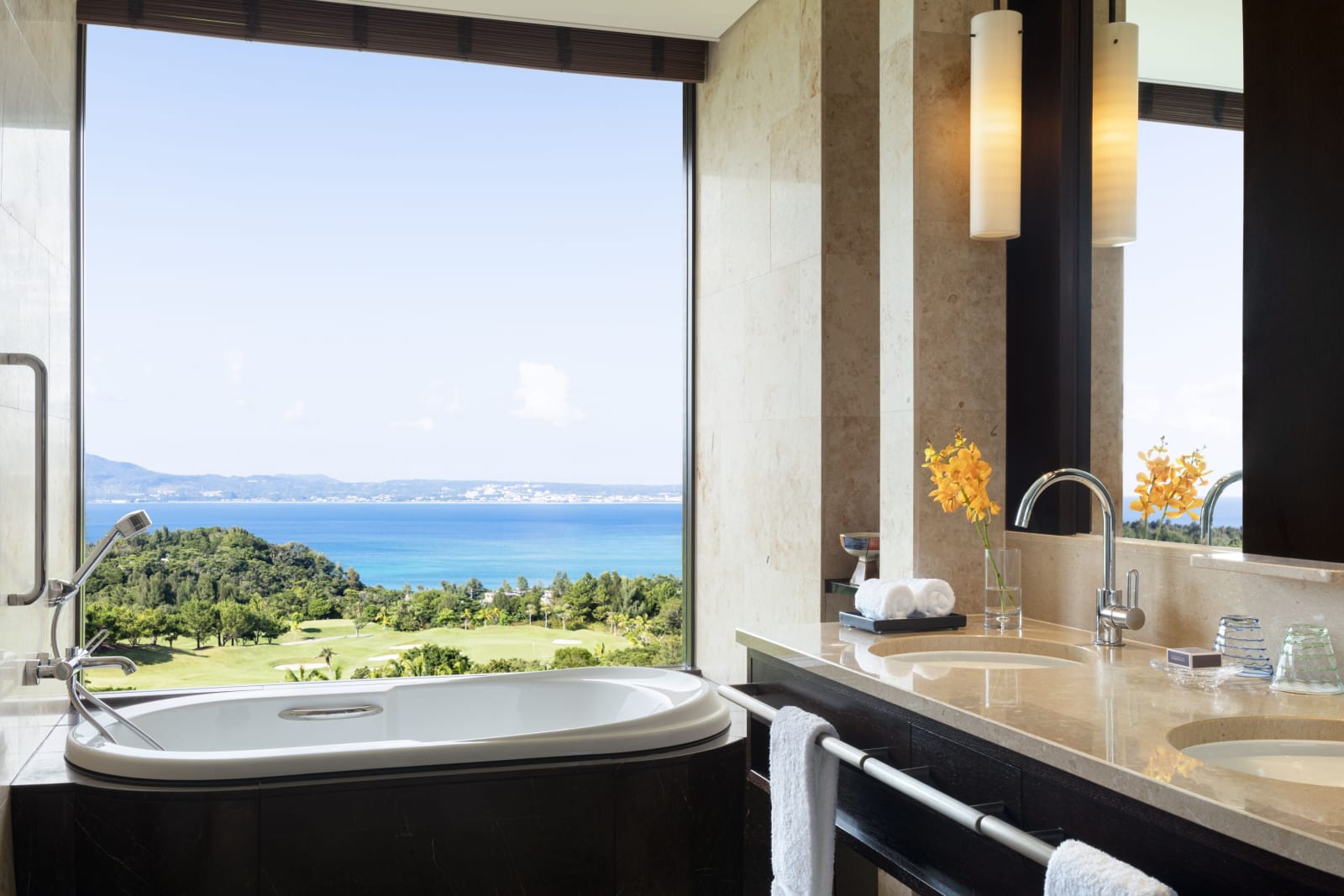 Marble bathroom with a bathtub set beside a full-height window