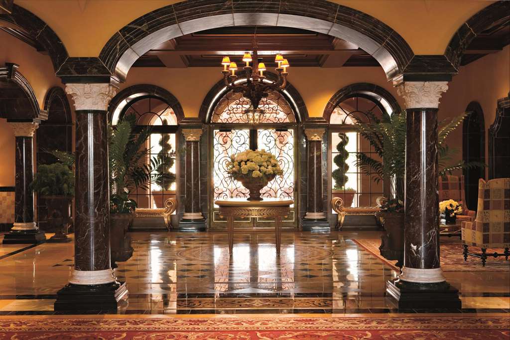 Arched lobby colonnade with marble floor and chandeliers