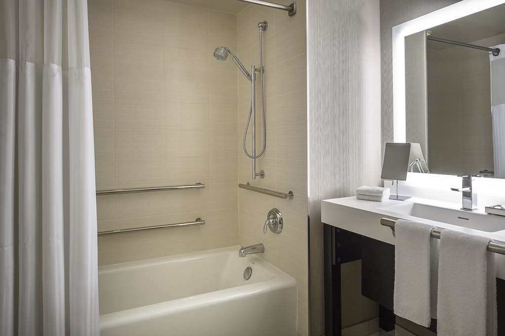 Accessible bathroom with grab bars beside the tub and clear space under the vanity
