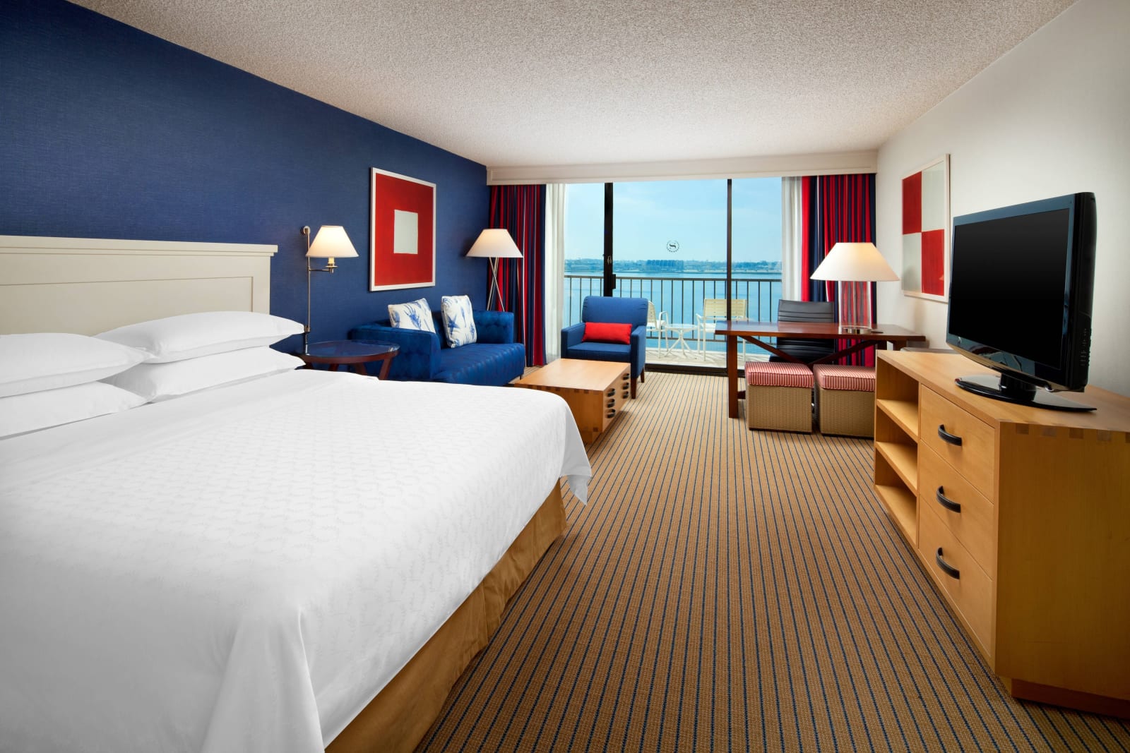 Older style guest room with deep blue palette, patterned carpet and dark joinery