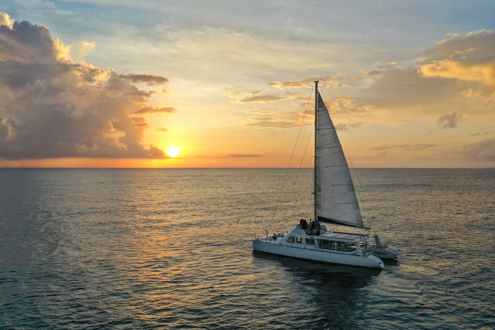 Catamaran sailing on the sea at sunset