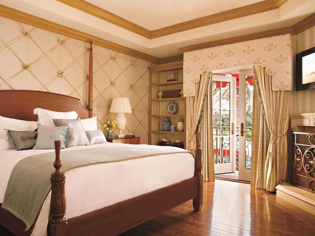 Guest room interior with a four poster bed and french doors to a terrace