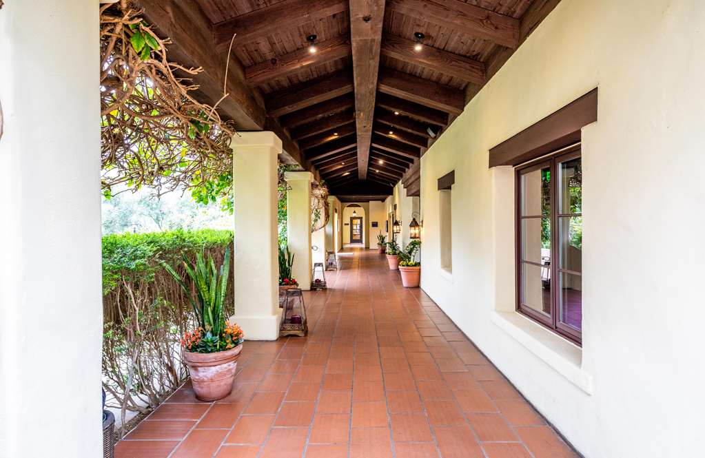 Timber beamed brick colonnade open along one side to a garden