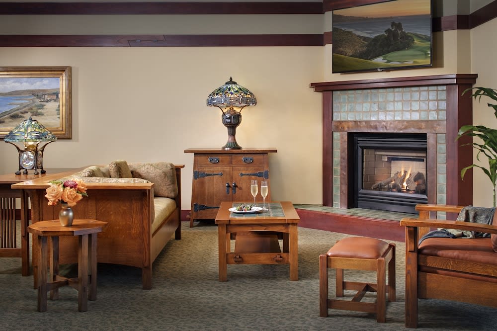 Sitting room with leaded art glass lamps, timber furniture and a tiled fireplace