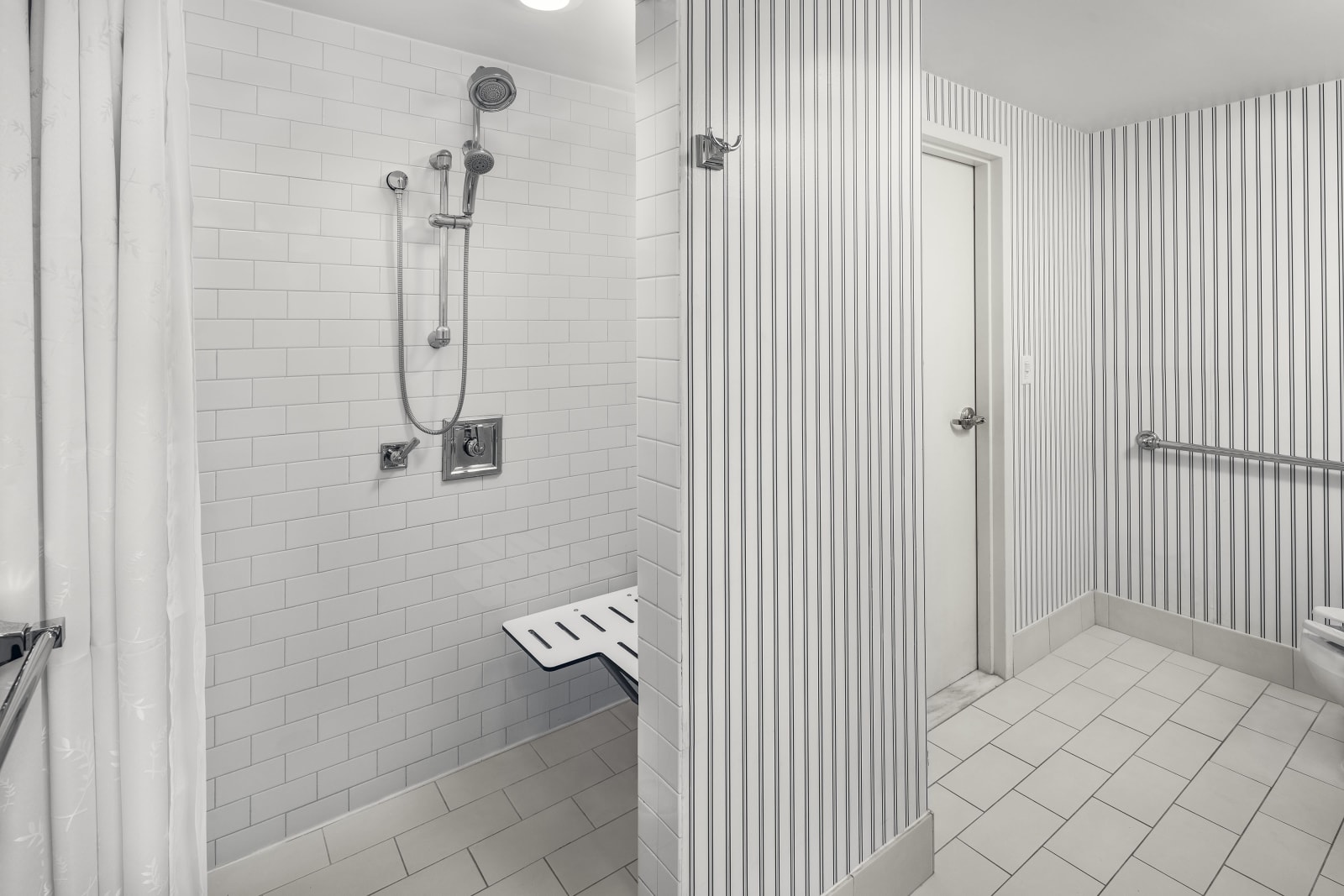 Roll in shower with wall grab bars and a folding seat