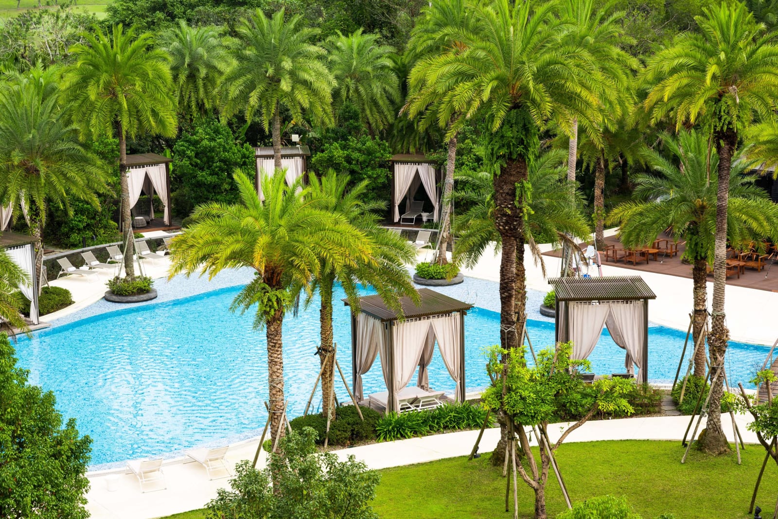 The tropical outdoor pool with palms and cabanas