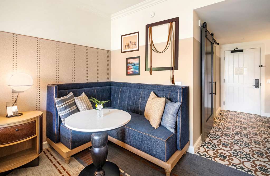 Built in banquette in a guest room with a horse bridle mounted on the wall and a barn door to the right