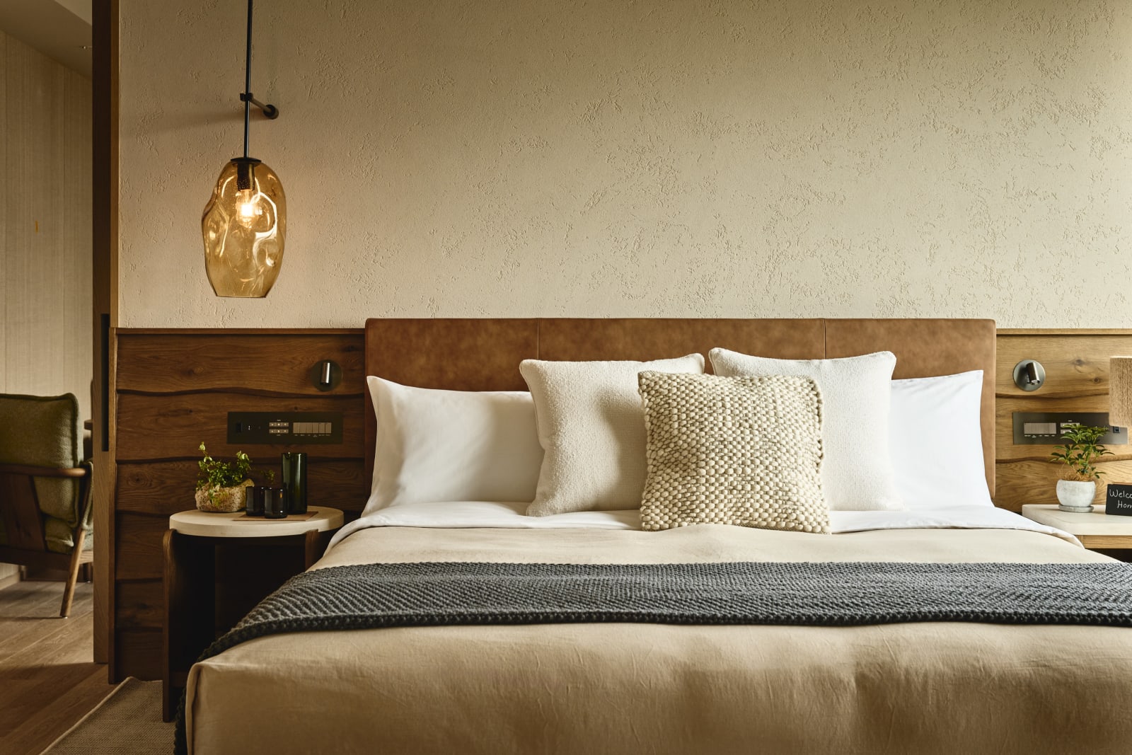 Interior of a guest room at 1 Hotel Tokyo, with a live-edge headboard and in-room greenery