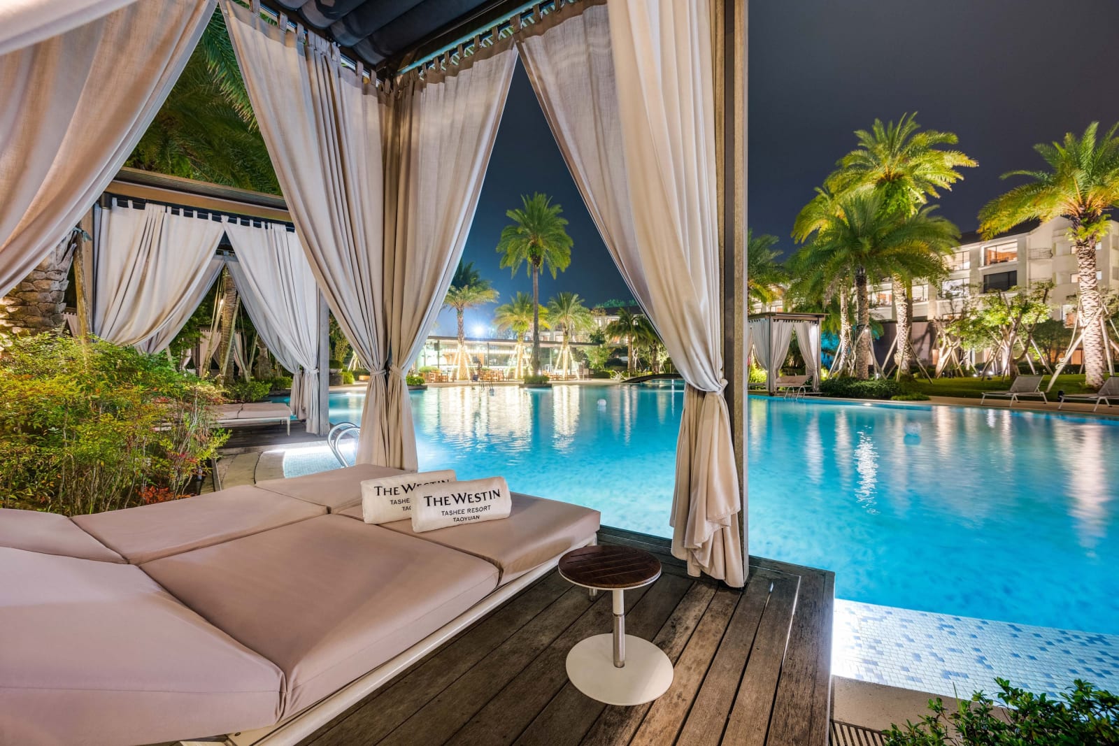 The outdoor pool and a curtained cabana after dark