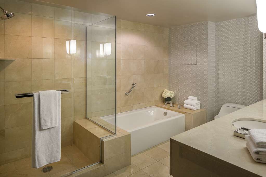 Suite bathroom with a tub and a separate glass shower side by side