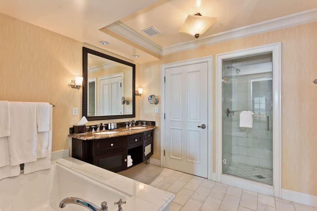 Bathroom vanity with a marble top, dark joinery and a large mirror
