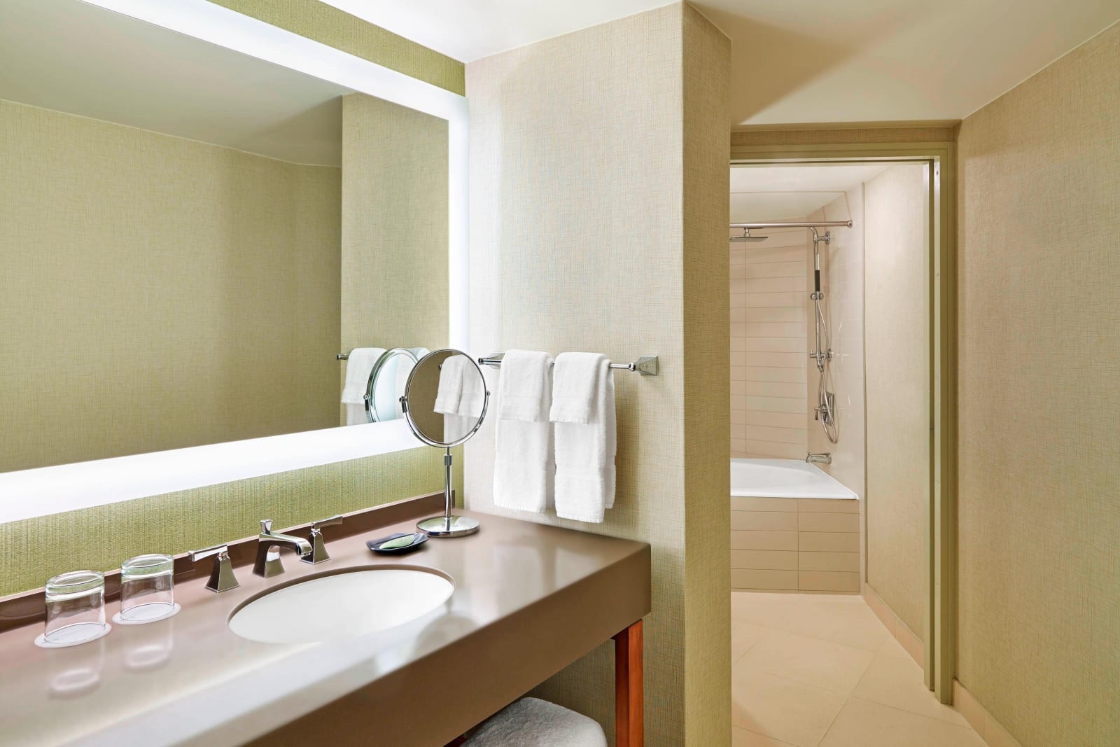 Guest bathroom with a long vanity, wide mirror and a shower alongside