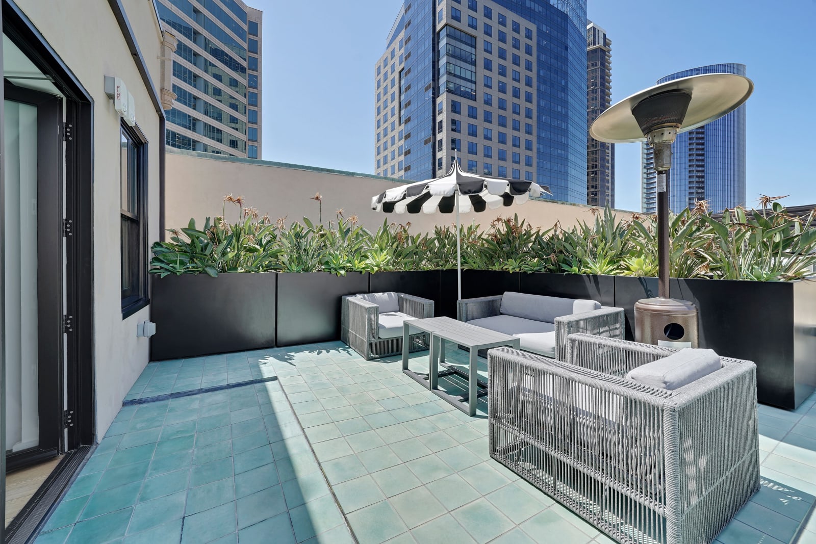 Rooftop terrace pool with loungers and downtown glass towers behind