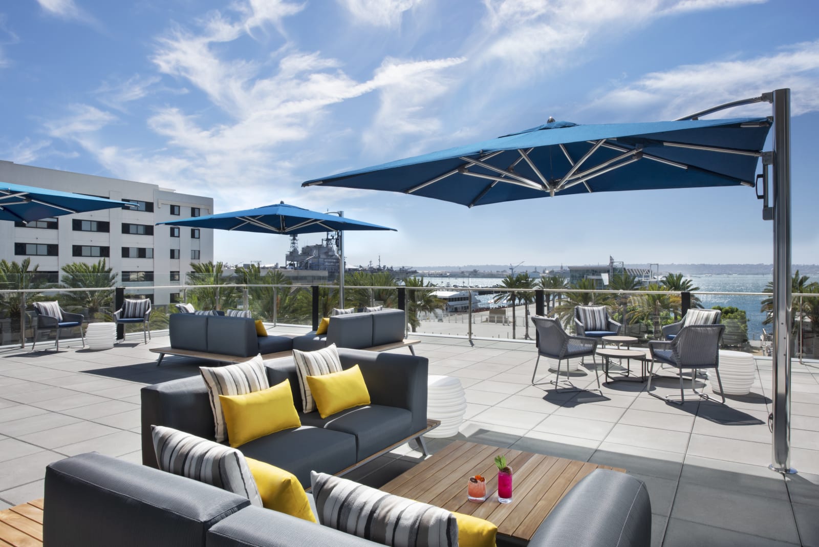 Lounge seating and umbrellas on the fourth floor deck with the bay beyond