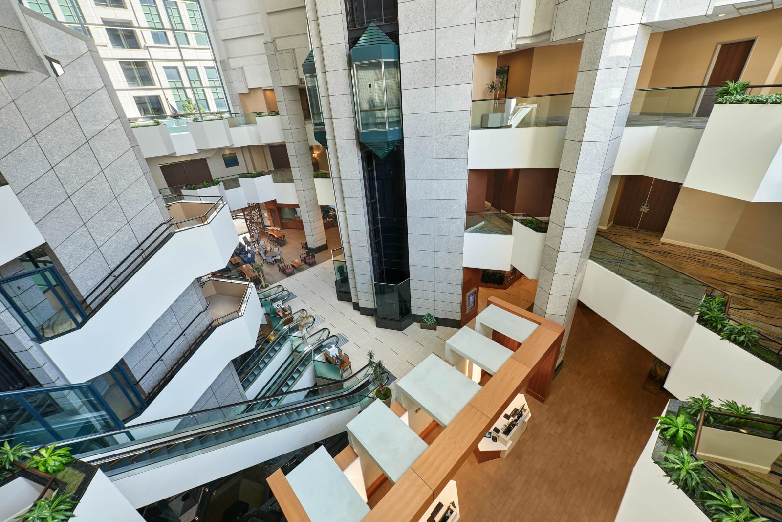 Looking down into the atrium from a high floor, showing scenic lifts and tiers of balconies