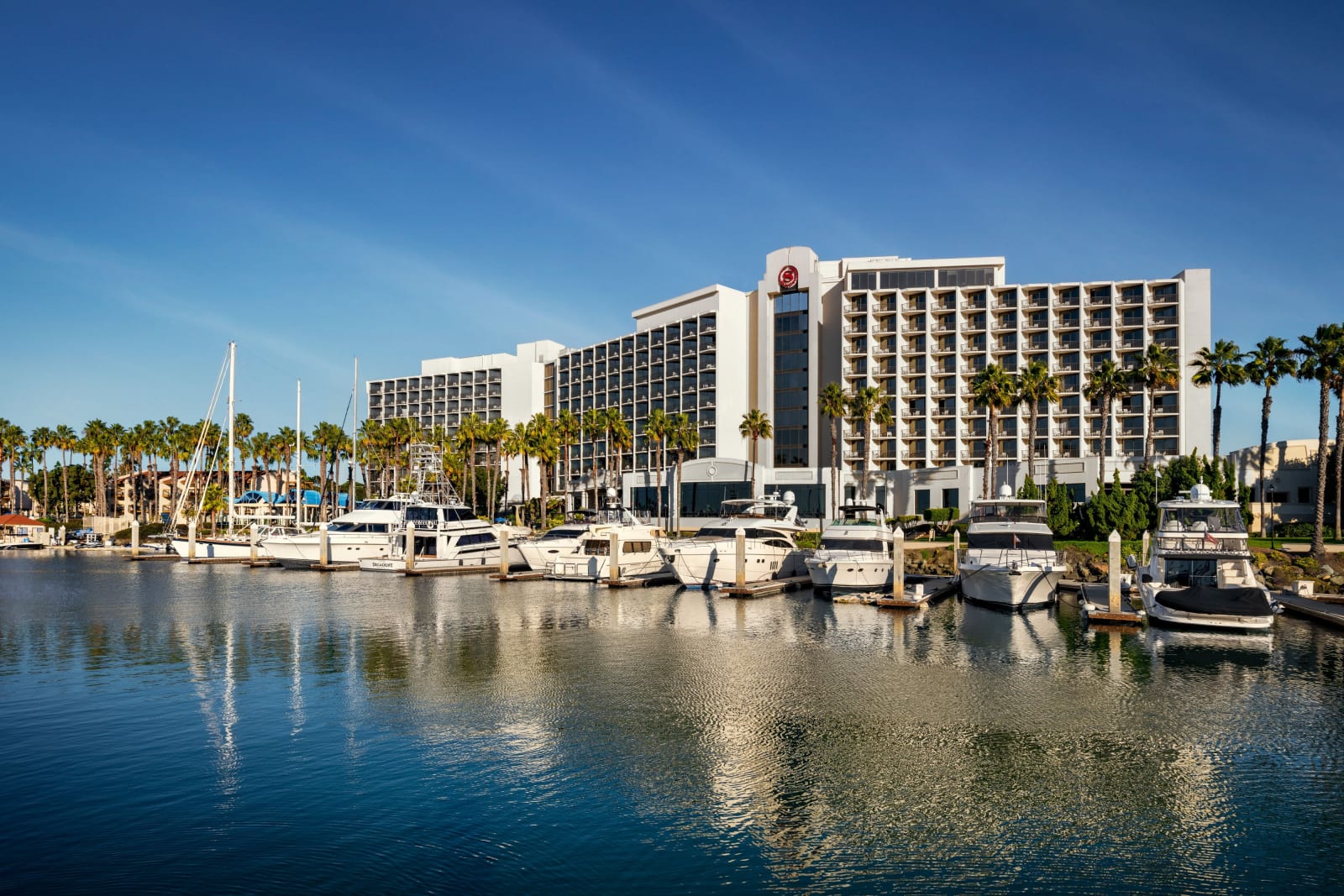 Aerial view of hotel towers with a marina full of sailboats in front