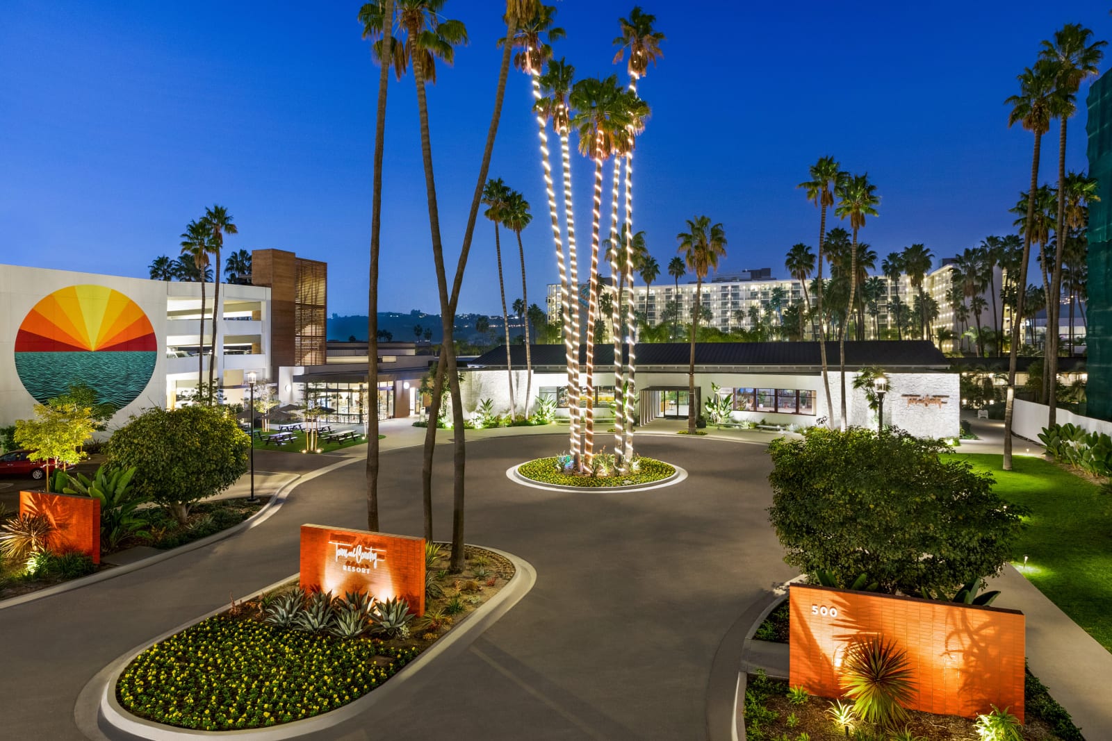 Driveway entrance flanked by palms with orange hot air balloon sculptures